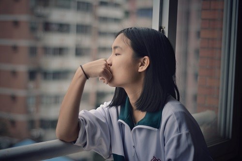 sad teenage boy looking out of the window